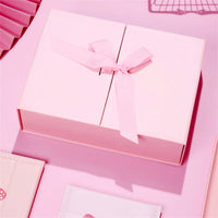 Caixa dobrável com fechamento magnético e laço decorativo.