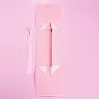 Caixa dobrável com fechamento magnético e laço decorativo.